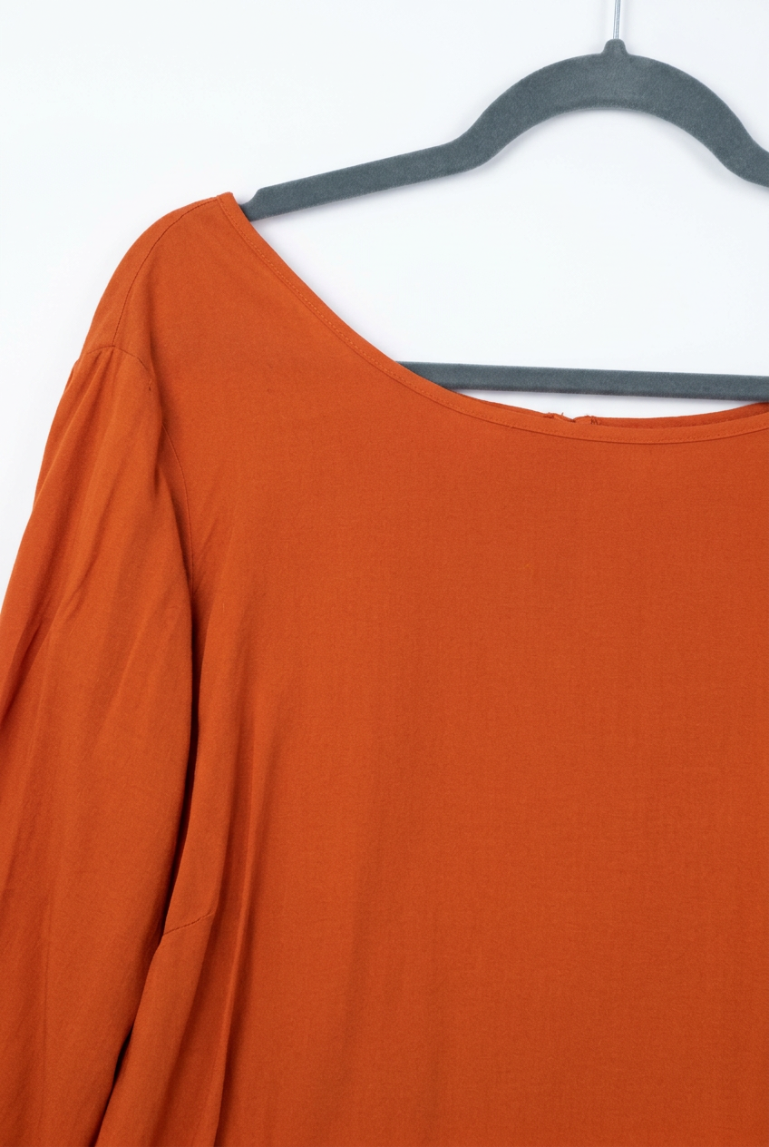 Orange blouse – left side and sleeve detail, white background
